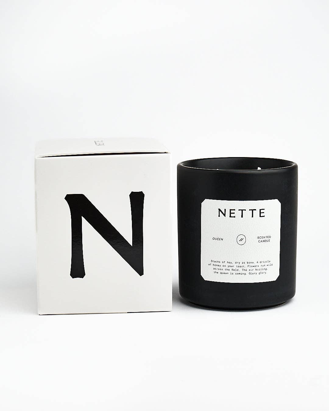 Queen candle beside its white box with a black N